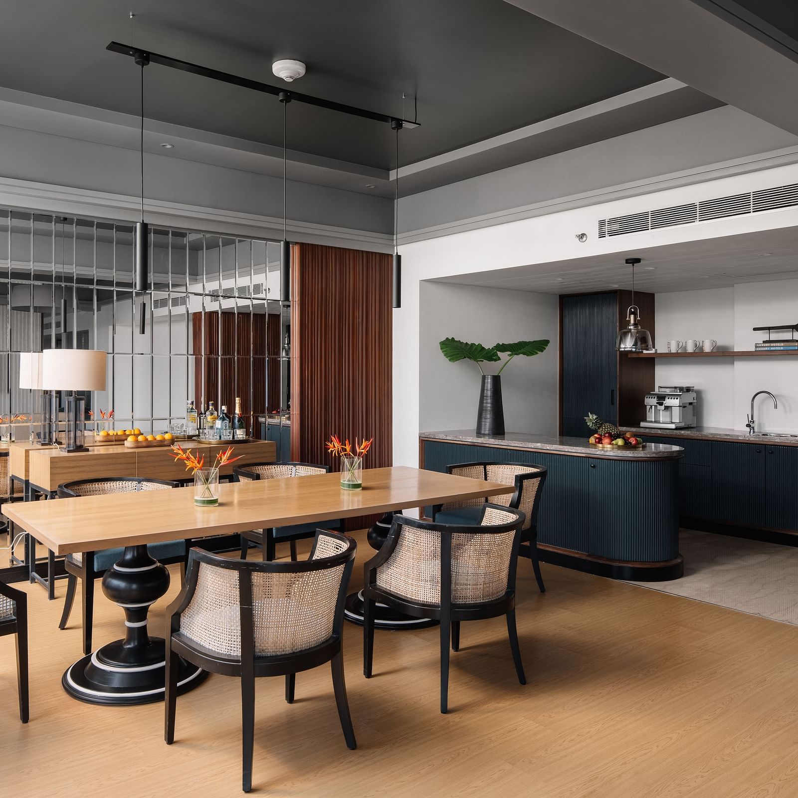 A seating area with a table and chair around it and a kitchen counter in the corner at The Raintree Hotel, St. Mary's Road.
