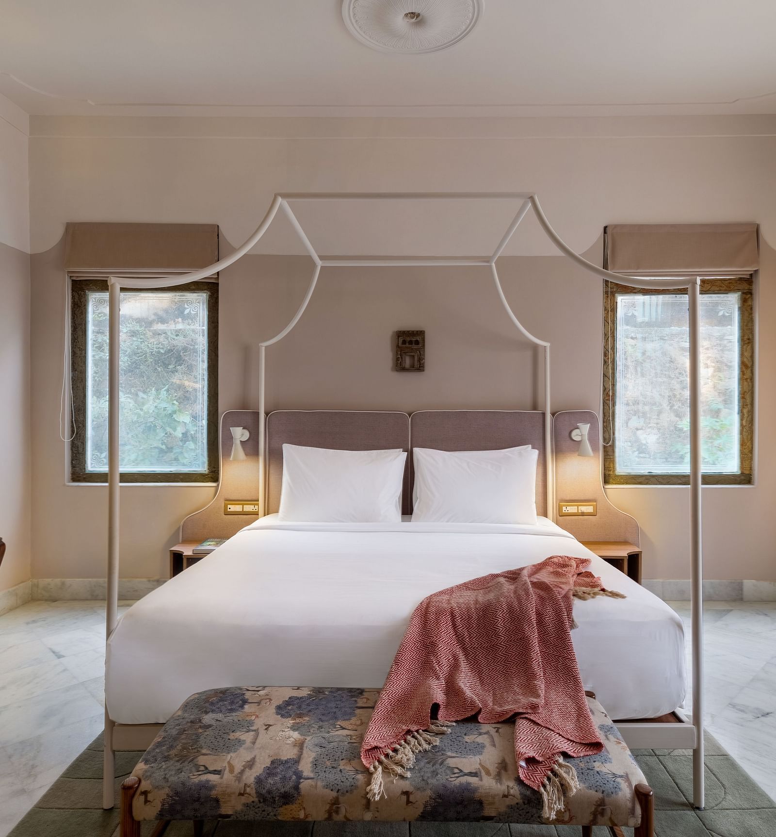 A double bed with a study table next to it inside Superior Room - Manuscript - Jhilwara Haveli, Udiapur