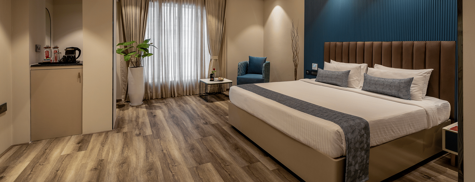  A modern room at the Citrine Hotel featuring a bed, a TV, and accent lighting on the ceiling and walls.