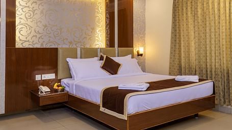 A room at Wyt Hotels, Rameswaram featuring a double size bed, bedside table, and lights installed behind the walls.
