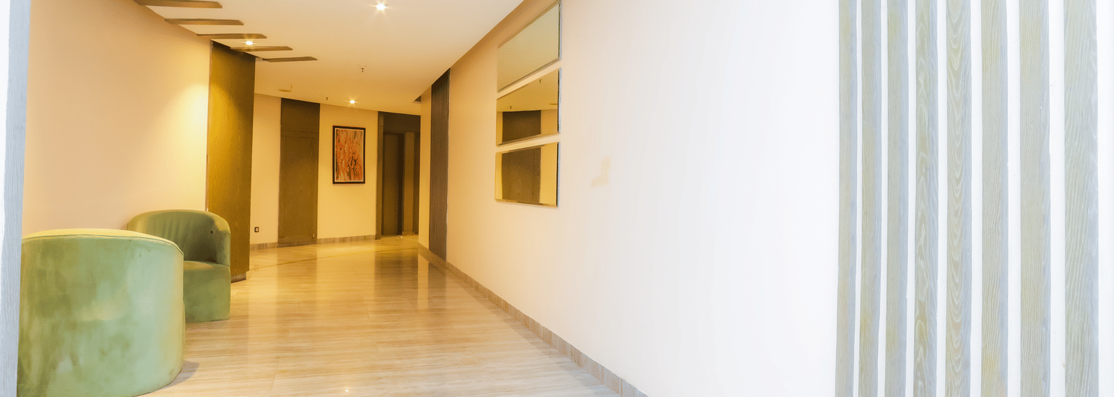 Bright, modern corridor with seating areas and curved ceiling design of Livbox Supernova, Noida.