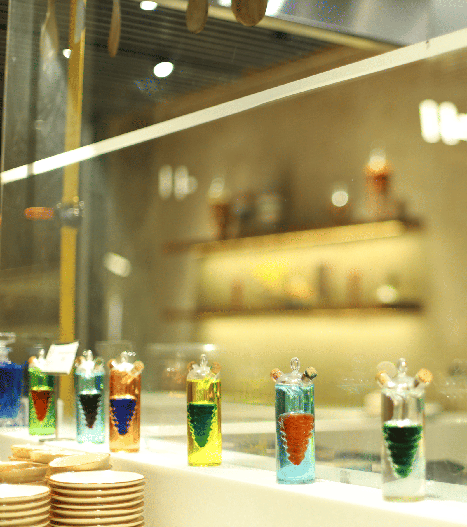 A vibrant display of colourful liquid art or cocktail ingredients behind glass at a bar in Pushkara Resort & Spa.