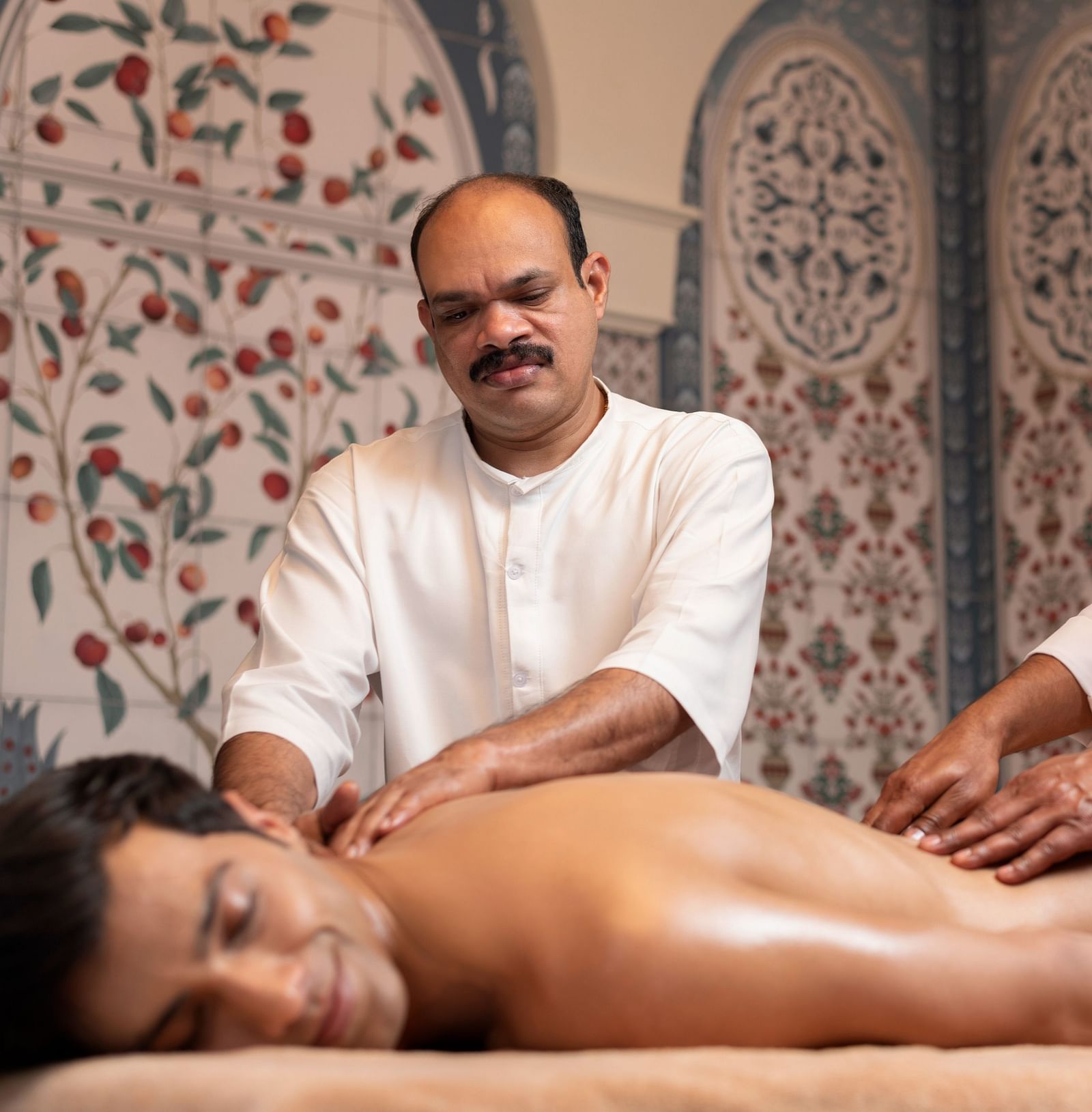 Two skilled masseuses performing synchronised Abhyangam at the Cinqtuair Spa - The Claridges New Delhi