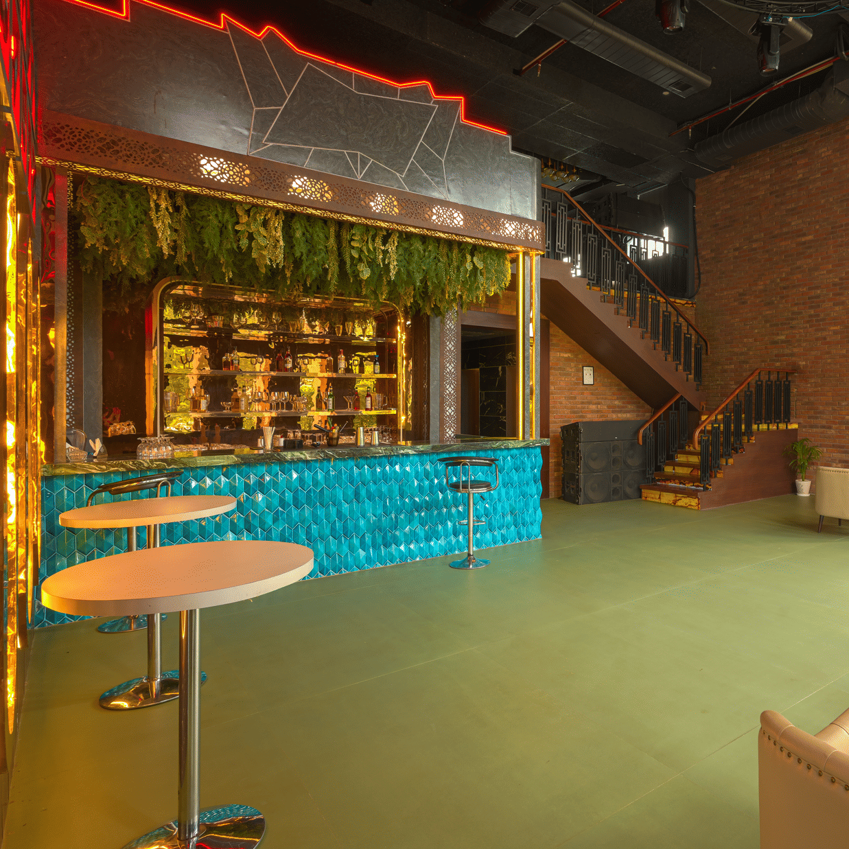 Contemporary hotel bar and lounge featuring a counter, cushioned seating, wooden finishes and warm decorative lighting.