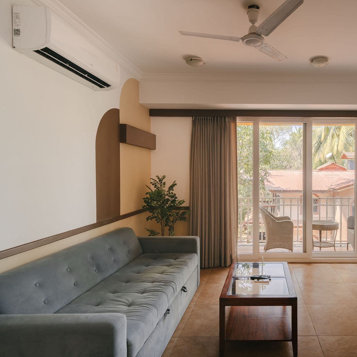 Well-lit living room with a cozy seating area and a balcony at the Two BHK apartment in Richmonde Ananta Elite, Goa.