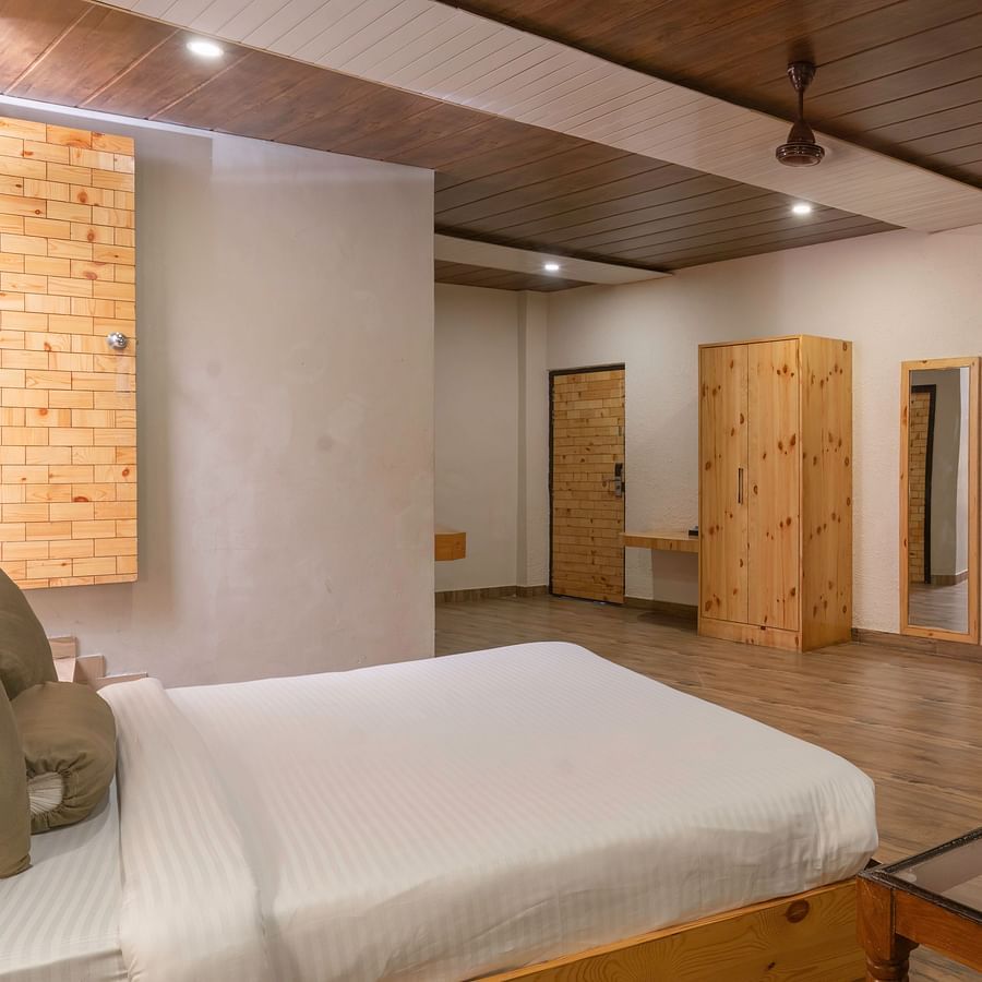 Cosy bedroom with sitting area and king bed at The Tattwaa Corbett Spa & Resort.