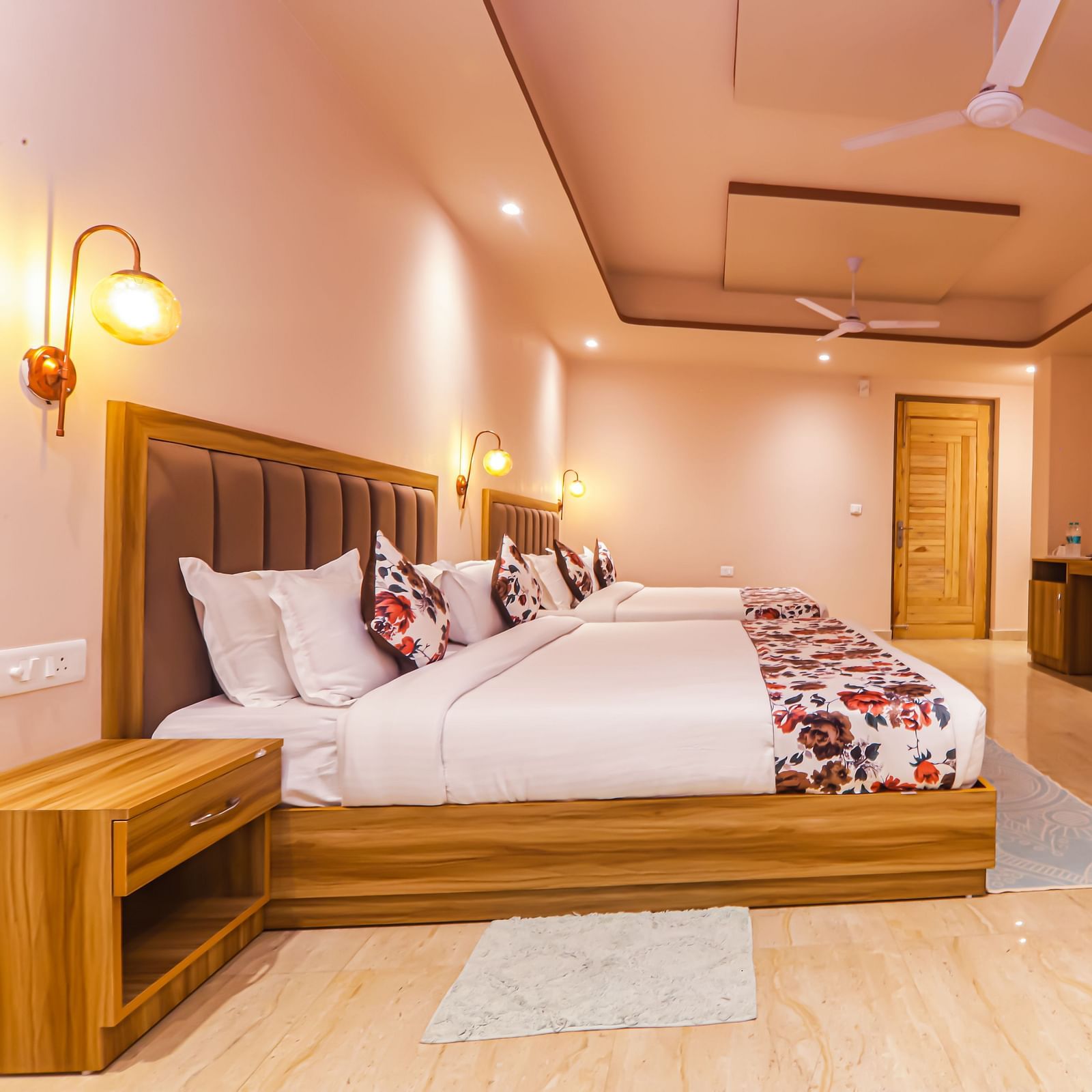 Side of a well lit room with two beds, TV mounted on the wall, wardrobe - Vedikant Resorts The Mallard Corbett.