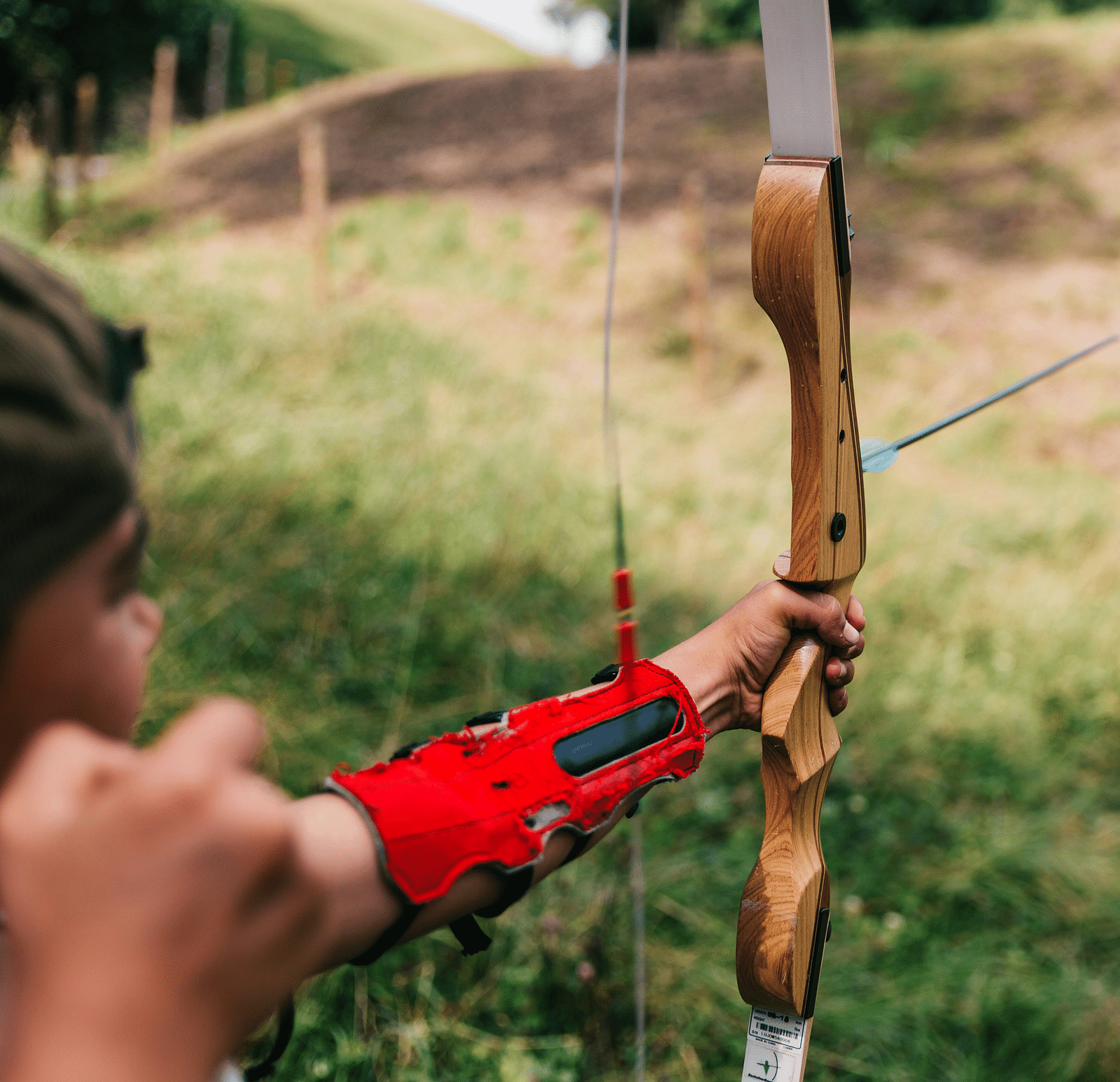 A child practicing archery in an open field.
