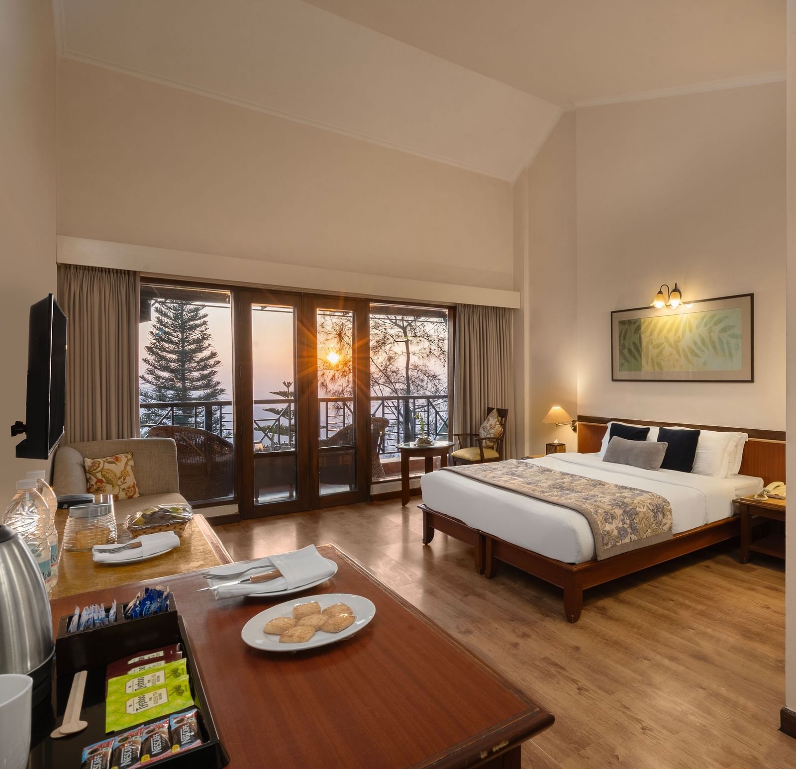 A corner view of Superior Room with plushy bed, table, wall mirror at Baikuth resort, kasauli.