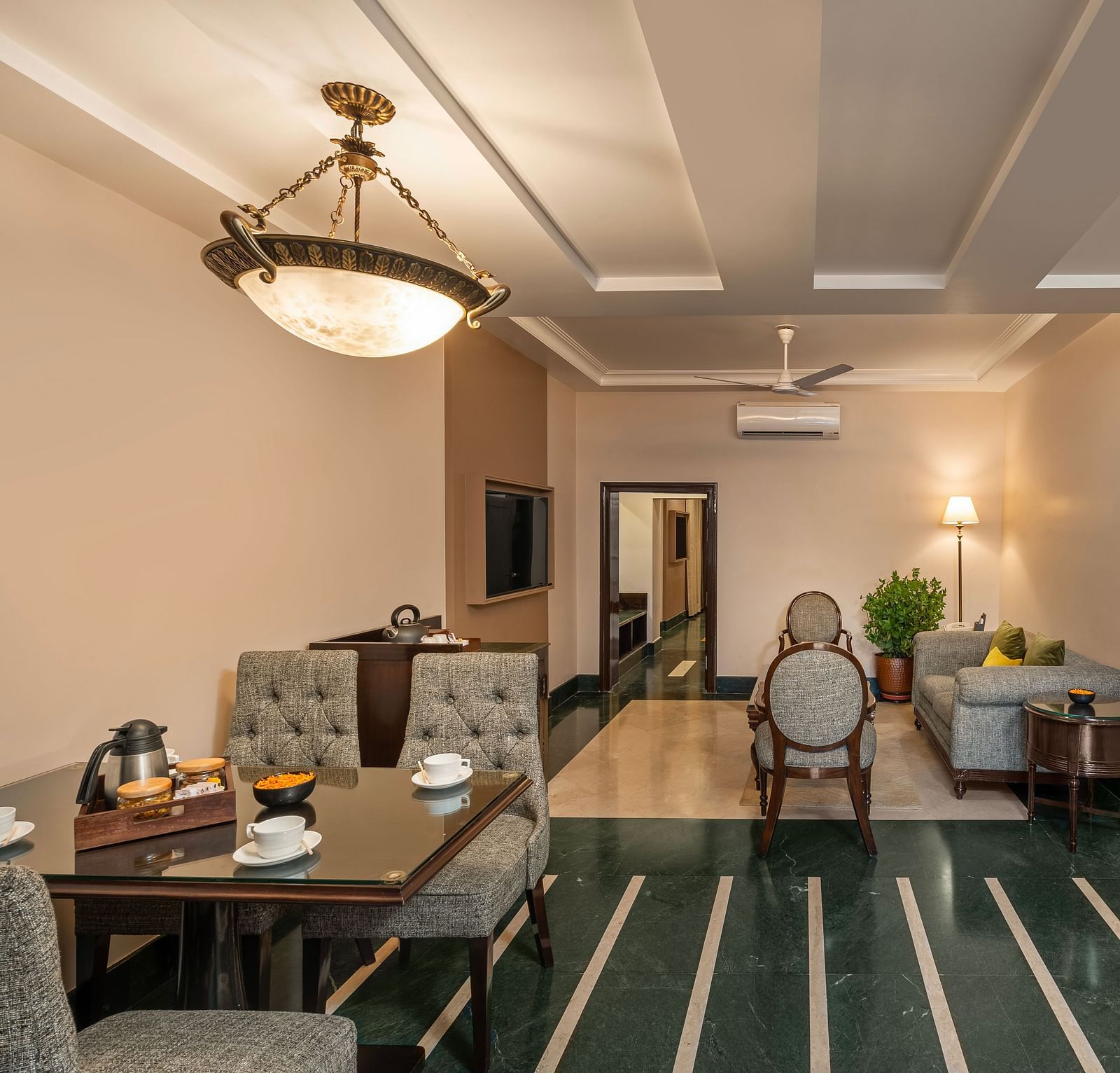 Maharaja Suite Living Room with a table set for dining and sofas for sitting - Ganga Lahari, Haridwar