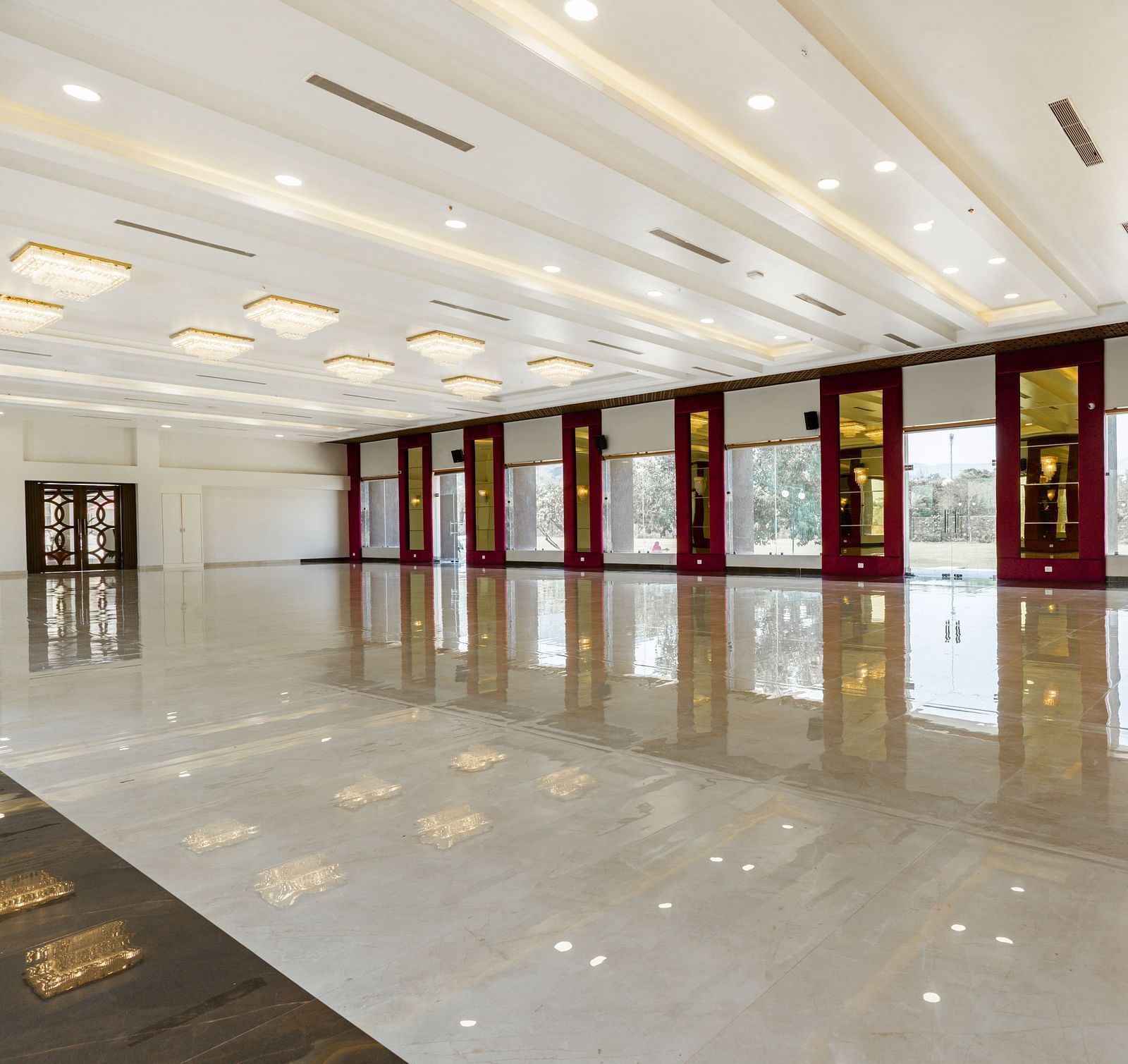 A slightly different angle of a long, empty hallway with a highly polished floor reflecting the ceiling and walls - Bamboo Saa Mulberry Resort, Pushkar