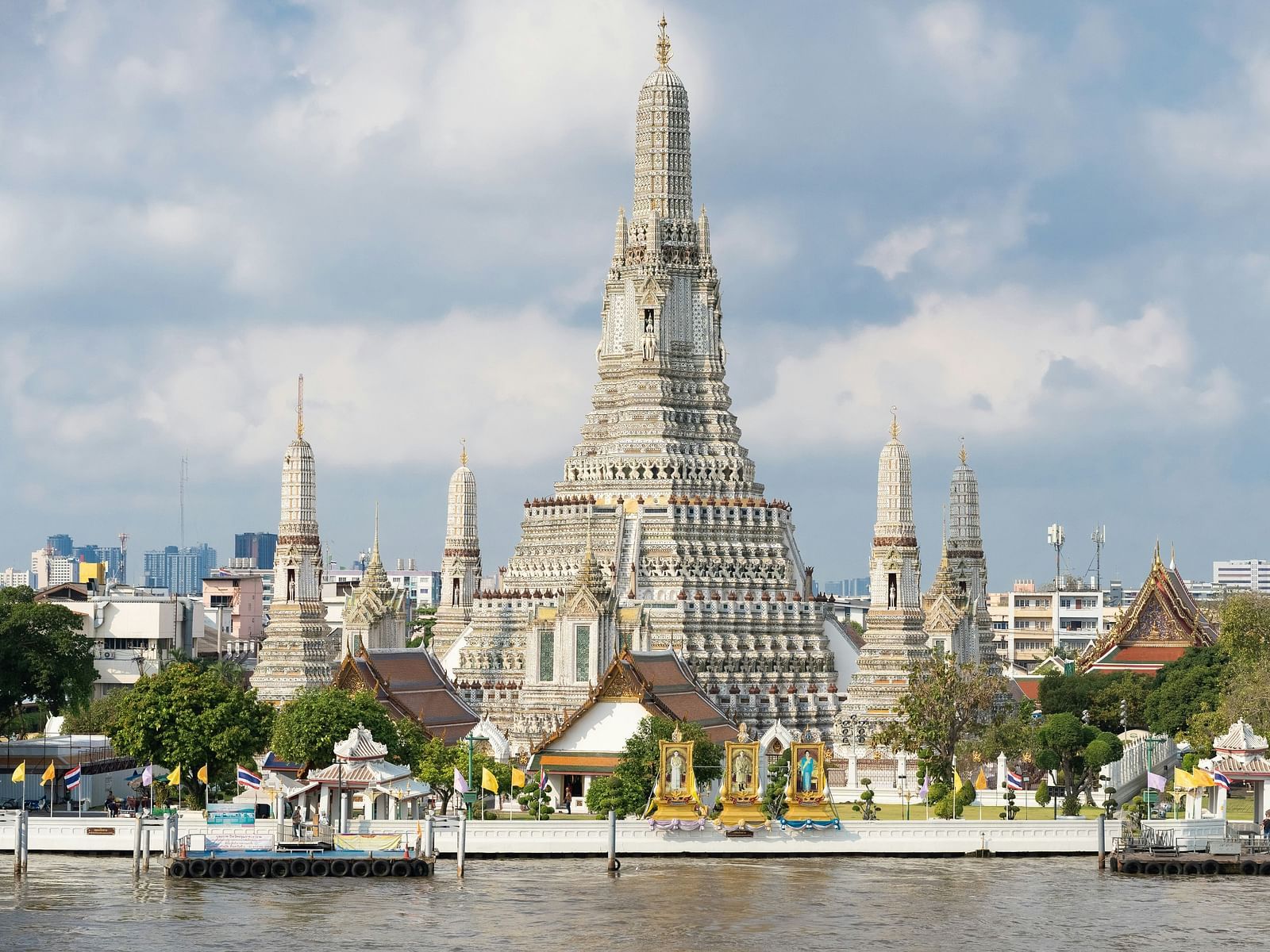 Facade image of Wat Arun with white clouds on blue sky in the background