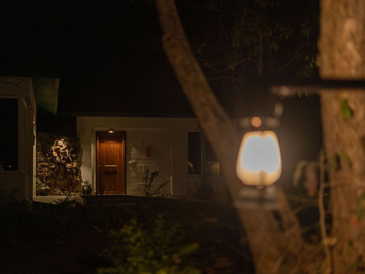 Exterior of a cottage at The Riverwood Forest Retreat, Kanha at night