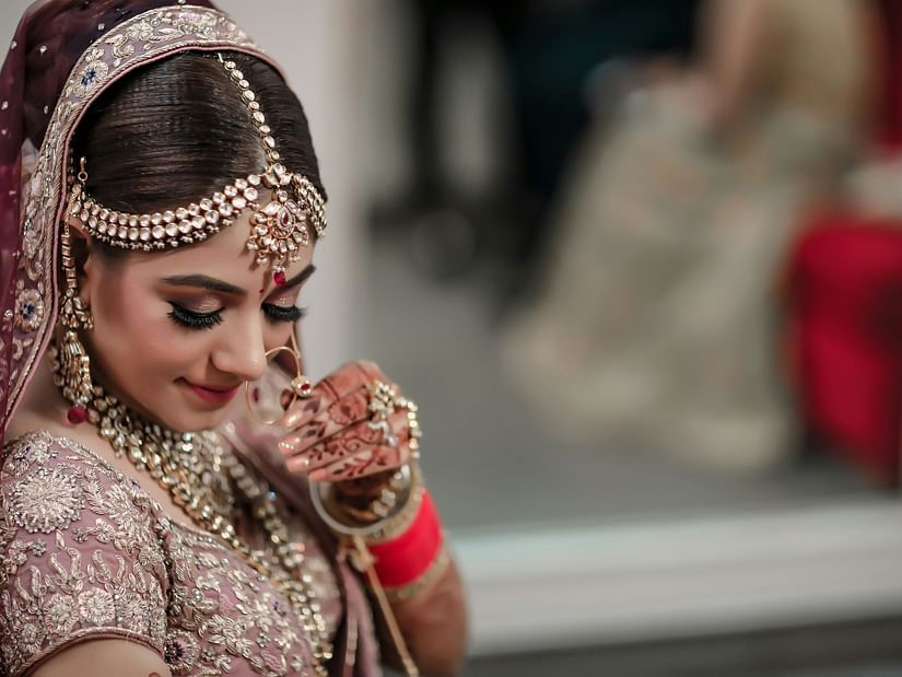 a model dressed as a bride posing for a picture wearing many jewellery