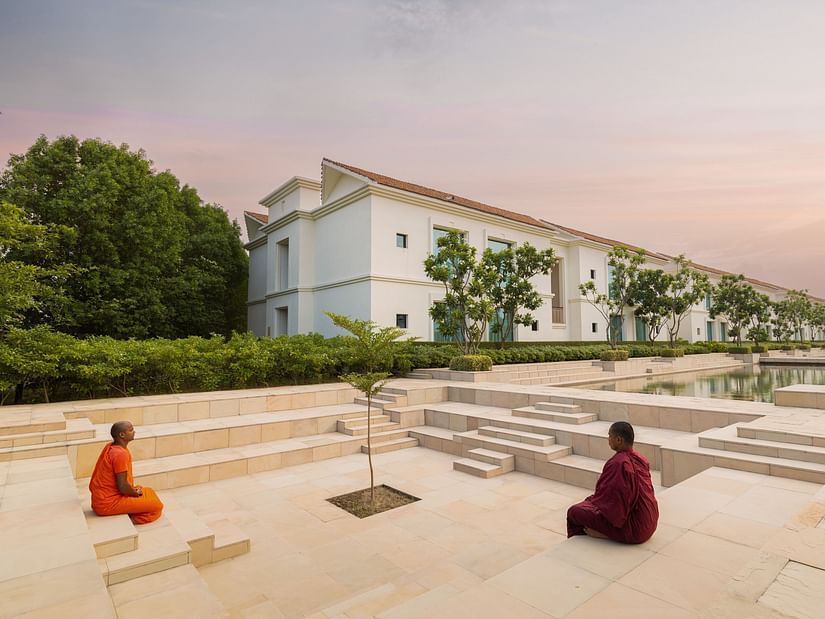 Two Buddhist monks meditating on a resort property. 