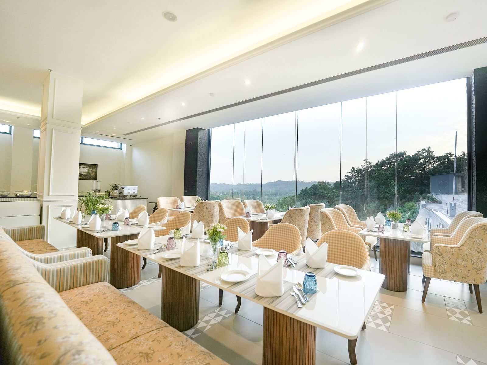 An image showcasing our cosy restaurant with dining arrangements that offer views of the mountains through the large windows - NAMAMI BY ZENQ BANKHANDI