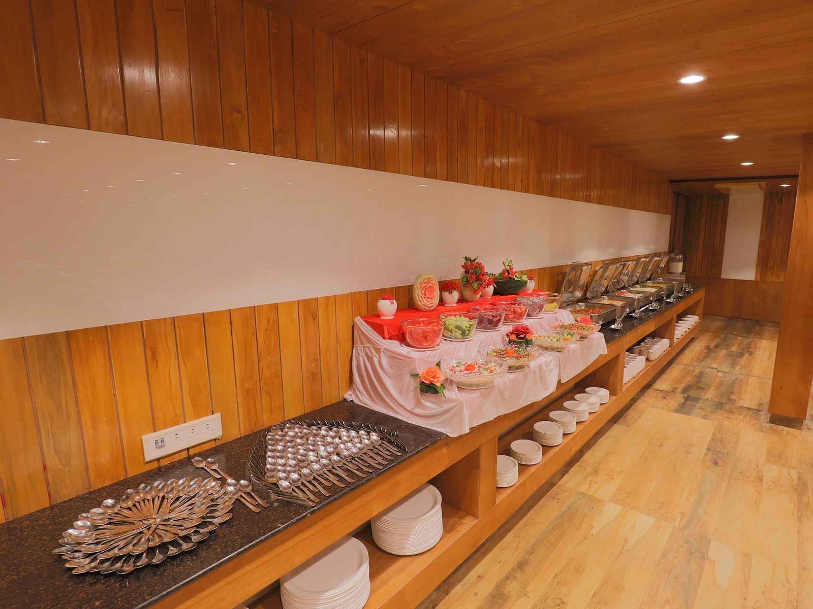 A buffet area with a variety of dishes displayed on a long counter - Vishal Lords Inn Gir Forest