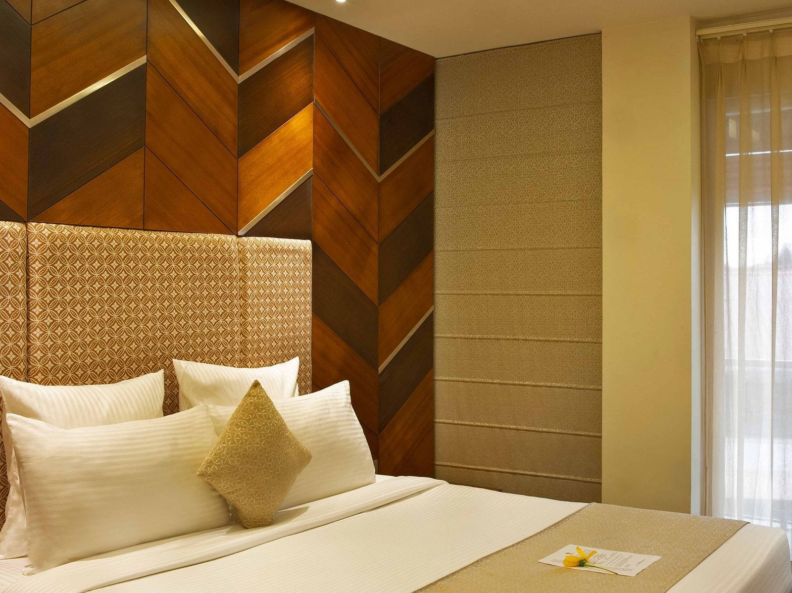 Image of Coral Suite at Coral Reef Hotel and Spa in Port Blair featuring a plush bed with pillows and cushions on it next to the door to balcony