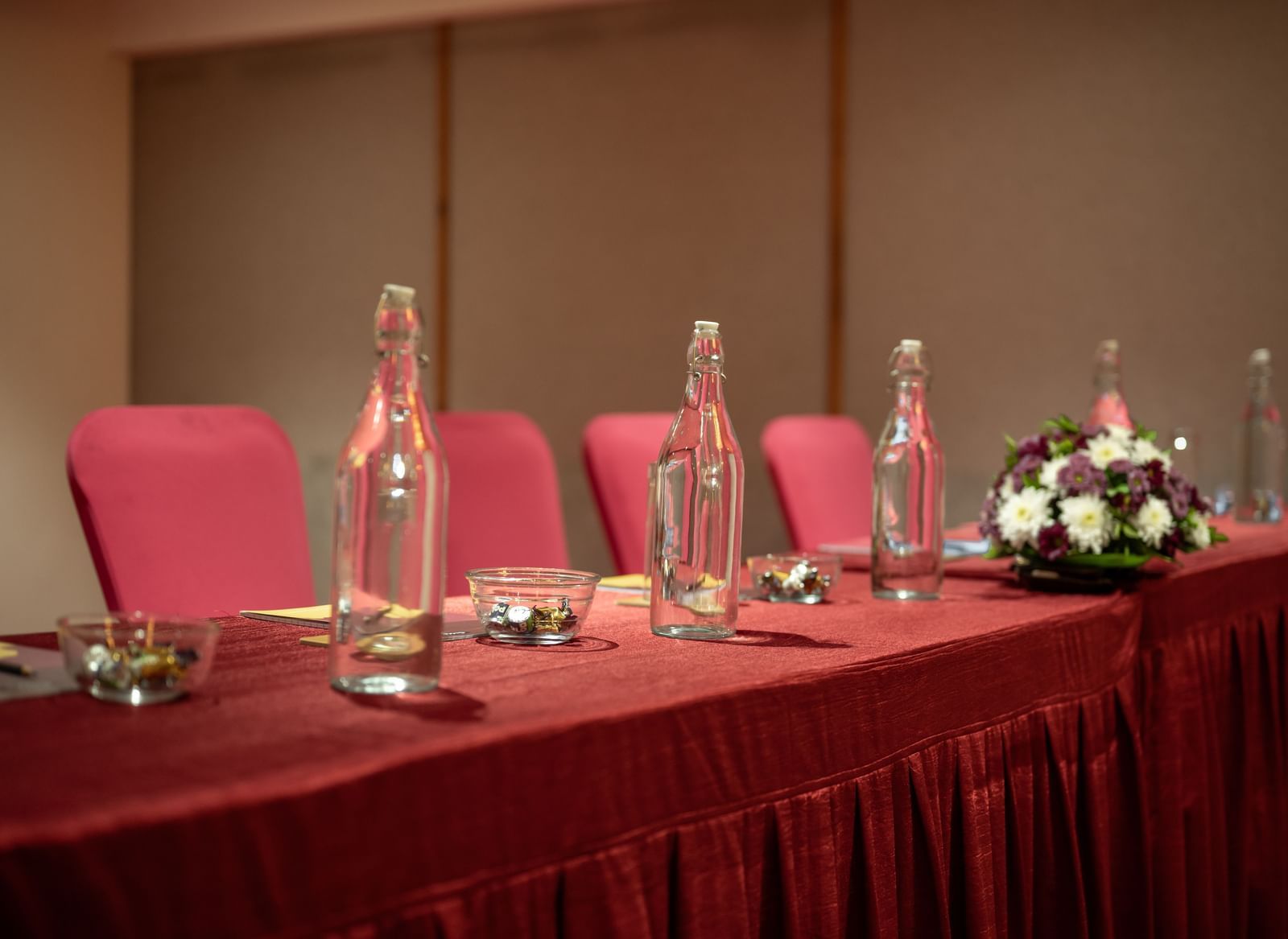 Close-up of meeting setup with glasses, and flowers at Hotel Royal Regency Chennai
