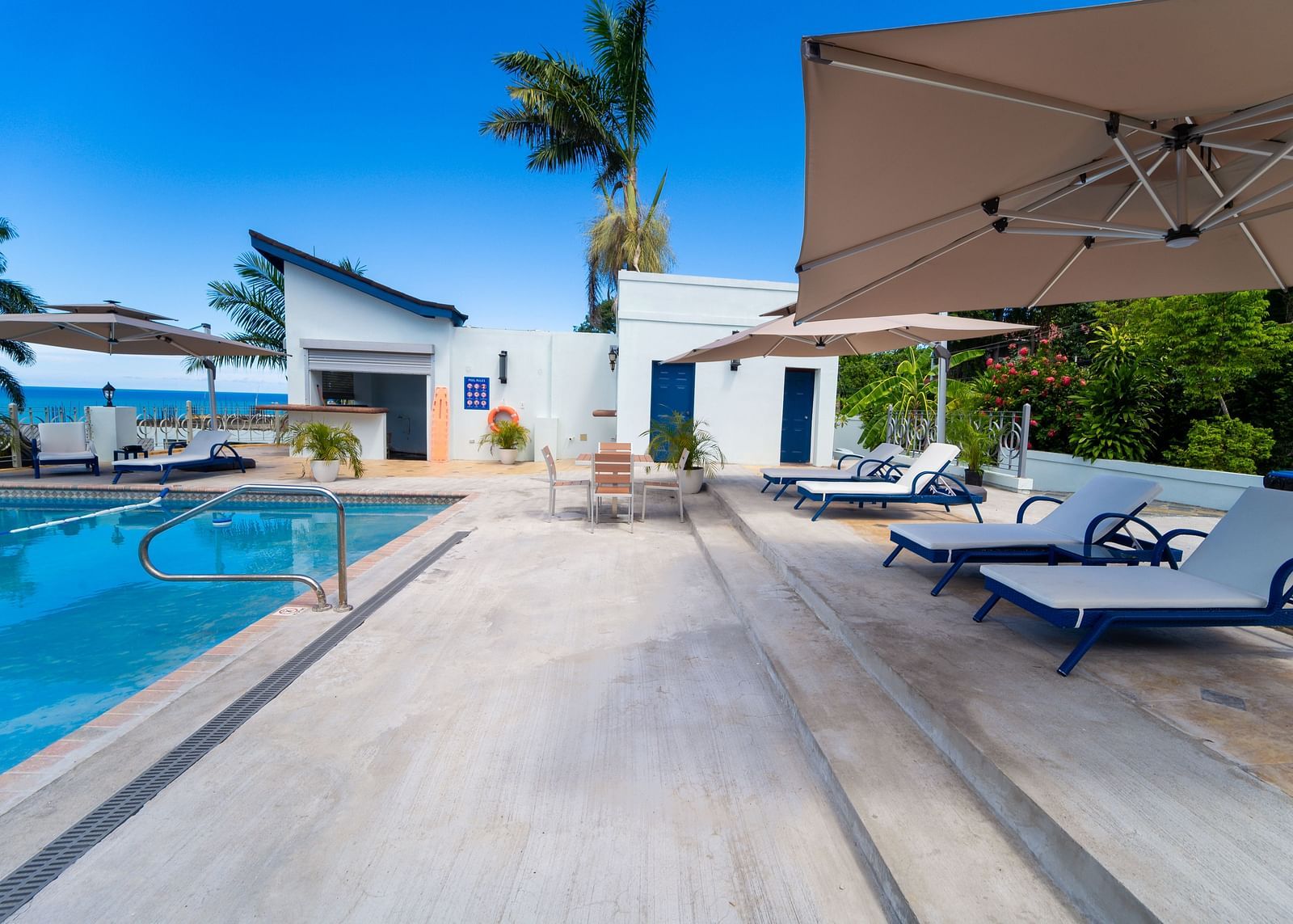 An image of sun loungers placed under canopies facing towards the pool - Hotel 39, Jamaica (Montego Bay)
