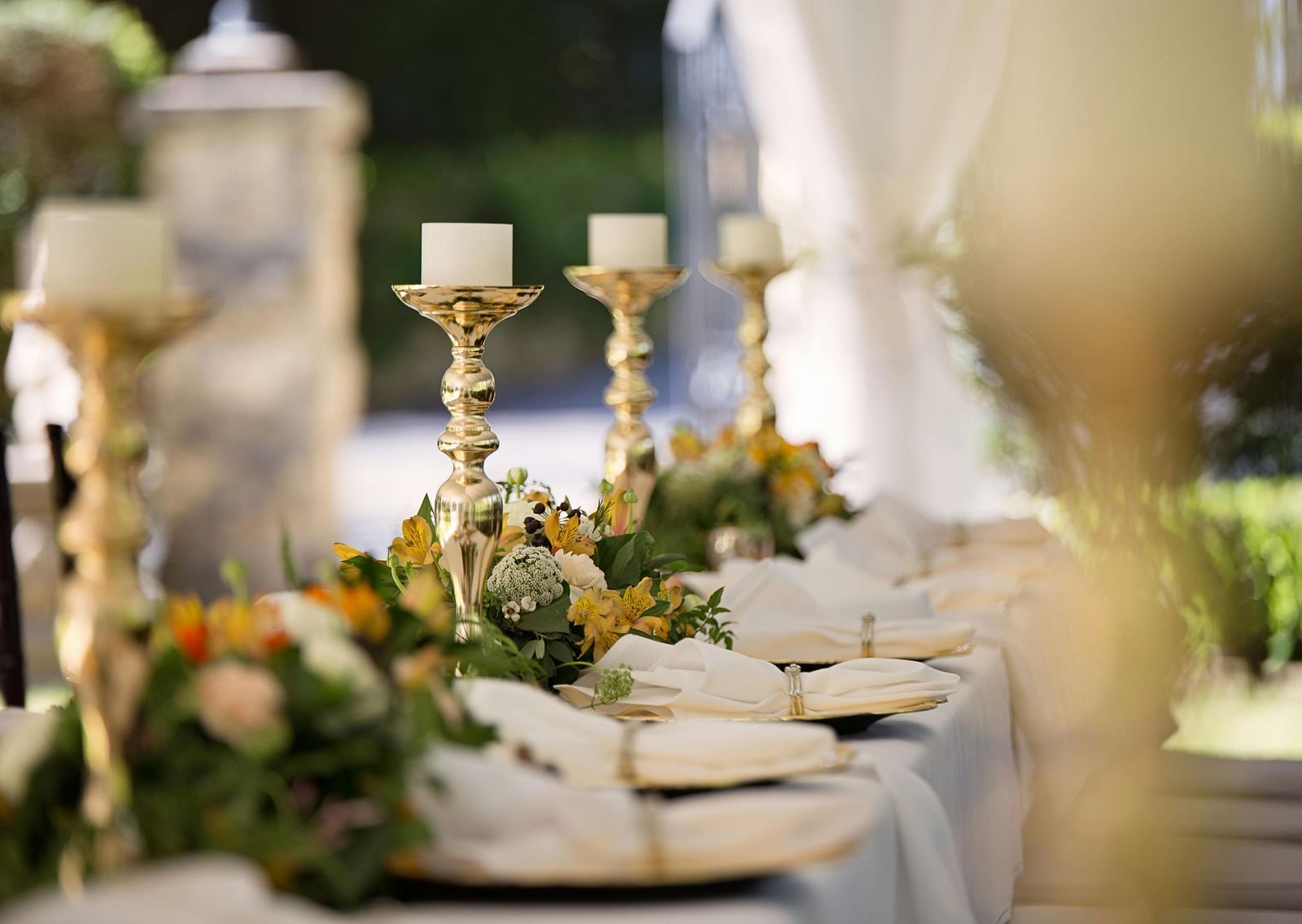 Selective focus of candlesticks on table with wedding set-up