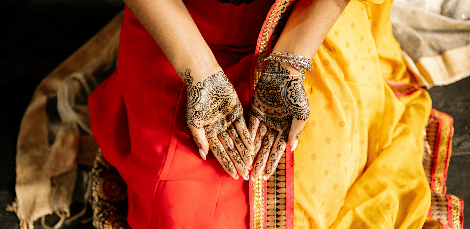 A woman with her palms open showing her mehendi on her hands.
