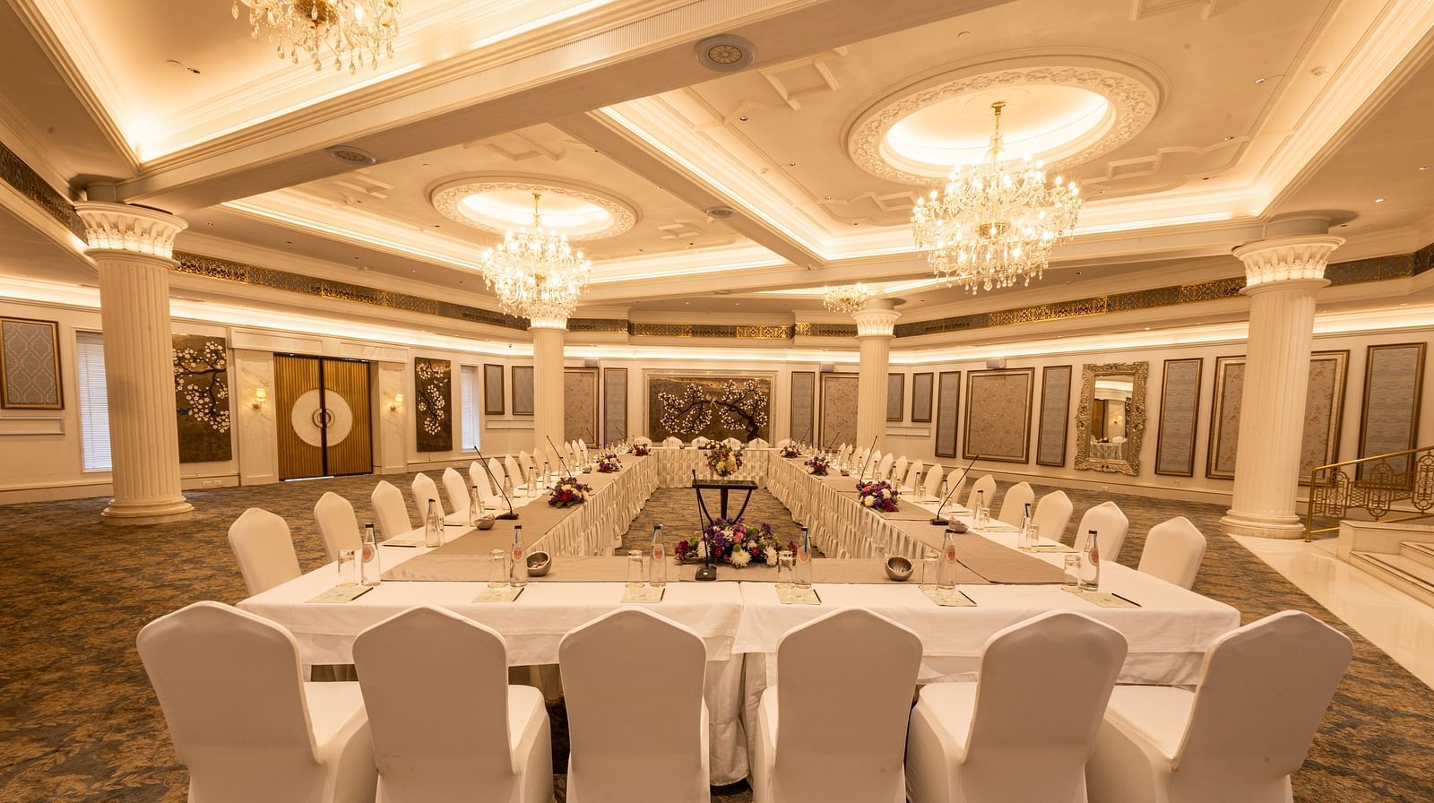 Image featuring the Viceroy Hall event venue at The Claridges New Delhi, showcasing seating arrangements and an elegant chandelier hanging overhead