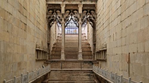 brown wooden stairs in between brown concrete walls