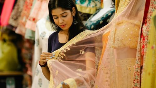 A young lady checking out bridal saris at a beauty exhibition Mumbai. 
