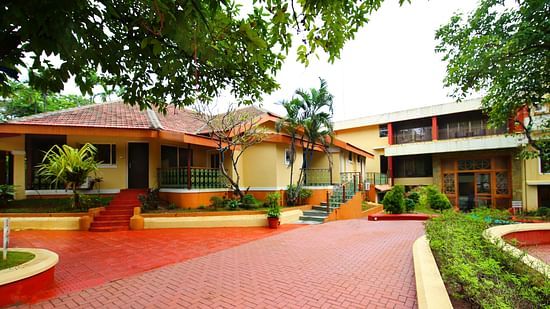 the outside space of the resort with rooms behind and lush greenery outside offering the best stay in Lonavala for family