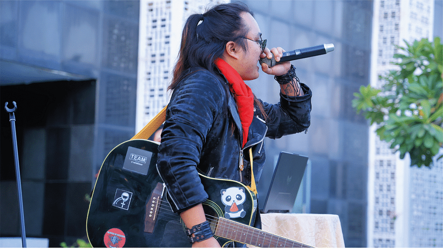 Picture of a person holding the guitar and mic on the other hand.