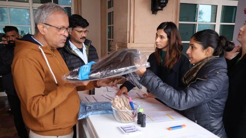 An image of a senior citizen receiving a packet of suit from a woman at Heritage Village Resorts & Spa