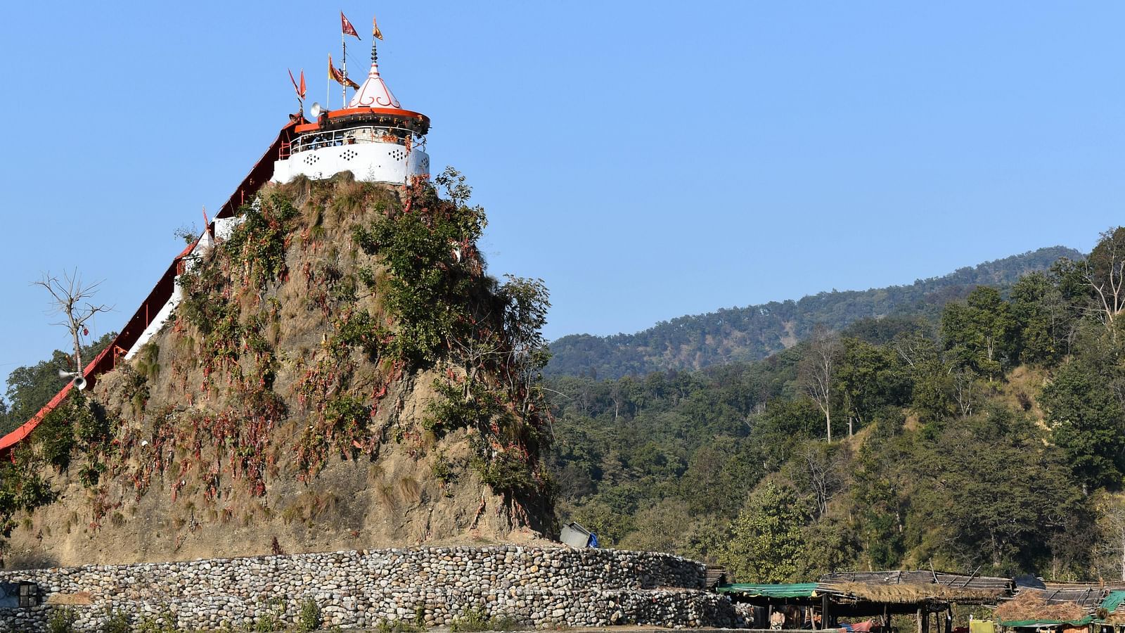 An exterior view of Garija temple  on top of a small hill surrounded by water body.
