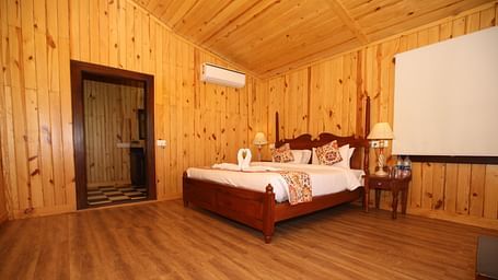 Spacious Kashmir Cottage Villa's Pool room with a king-sized bed, wooden flooring at Aanandam Resort & Spa