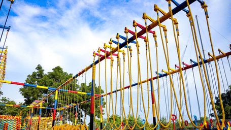 An extensive outdoor high ropes course stands tall against a blue sky - District Gravity Adventure Park, Hyderabad