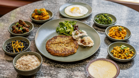 A rich spread of authentic Newari cuisine items, including Bara, Choila, and side dishes served at a restaurant in Bhaktapur, Nepal.