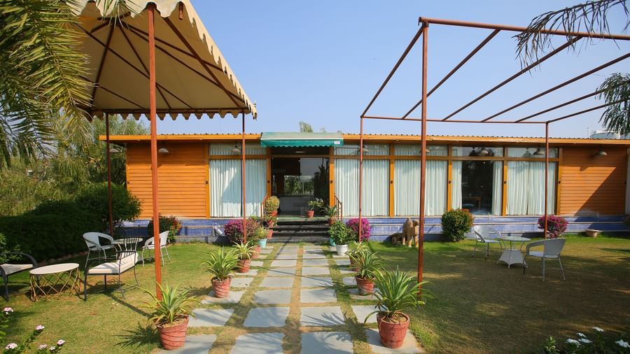 Elegant pathway leading into the hotel, featuring a roofed shed and small potted plants lining the side at Aanandam Resort & Spa