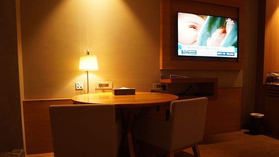 Spacious wooden table with a table lamp and wall-mounted television
