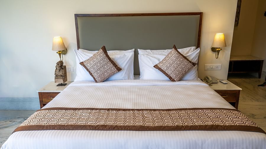 A cosy bedroom with a large, plush bed and soft lighting - Rajbagh Wellness, Udaipur