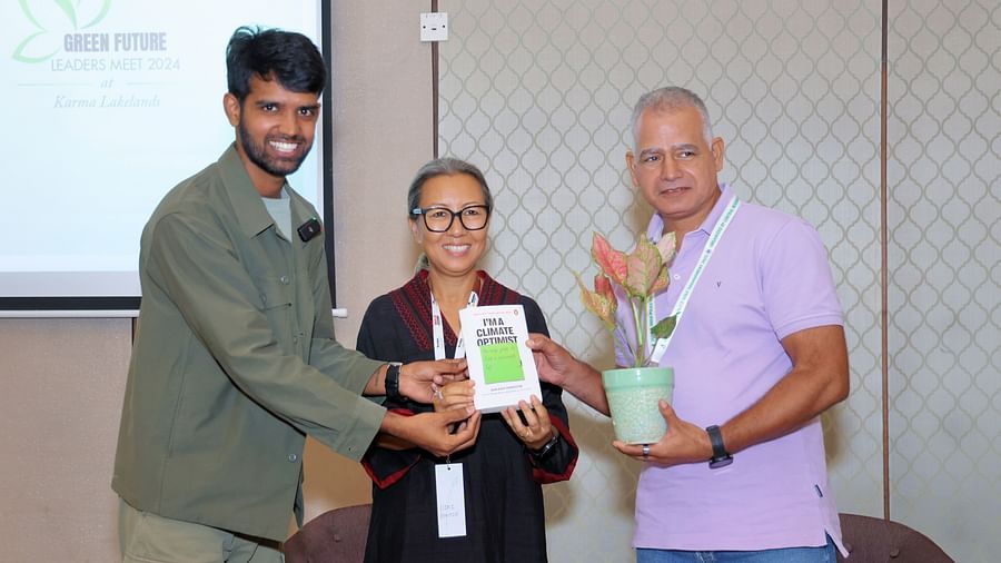 Image of a people handing over the book to a guest - Karma Lakelands.