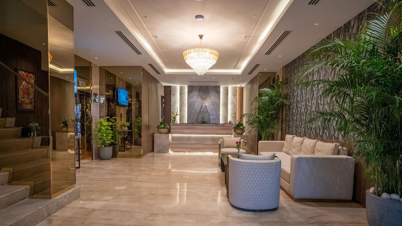 Reception desk with modern design, lighting, plants and seating area at ASTER GRAND BY ZENQ SAKET.