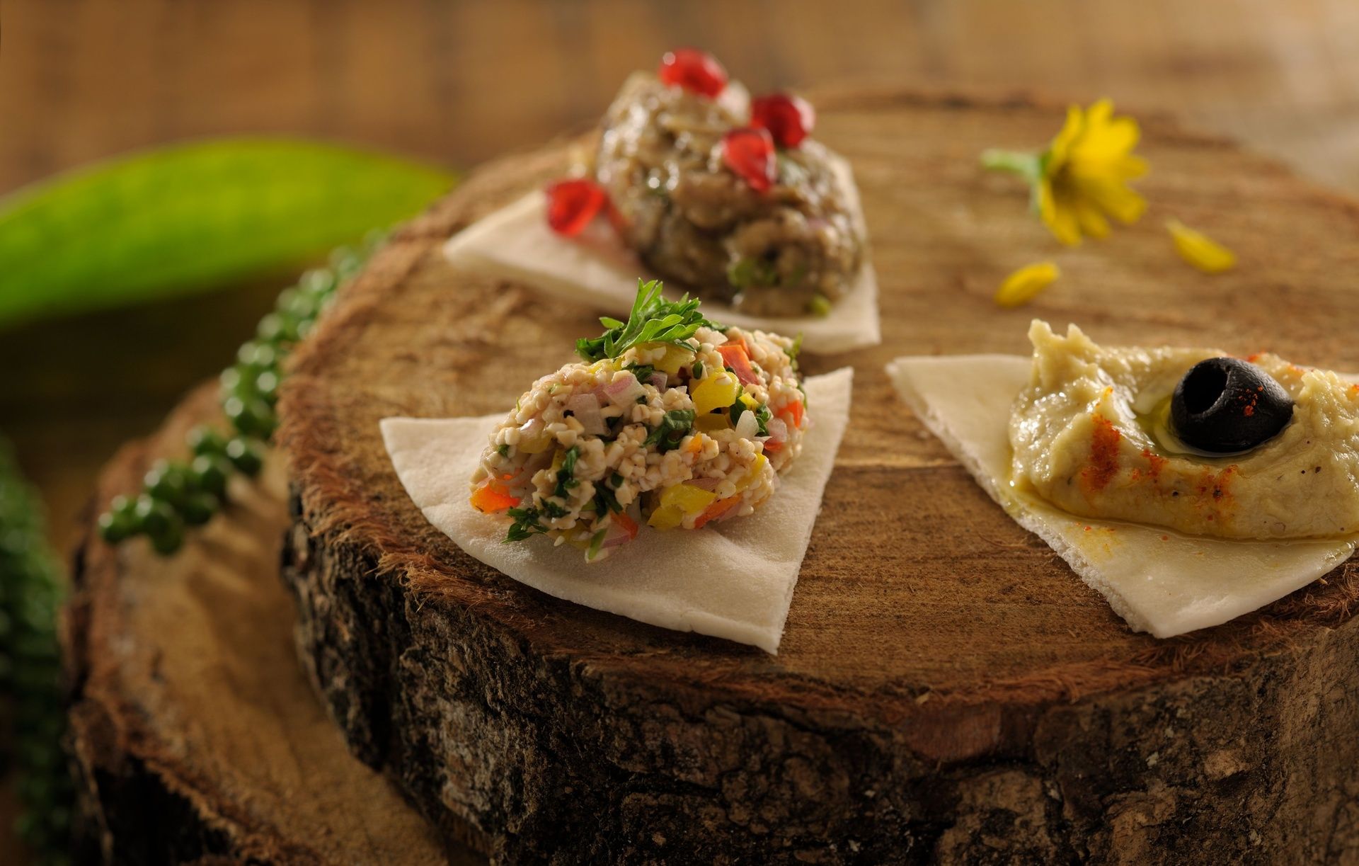 Mezze platter with hummus, baba ganoush on wood.