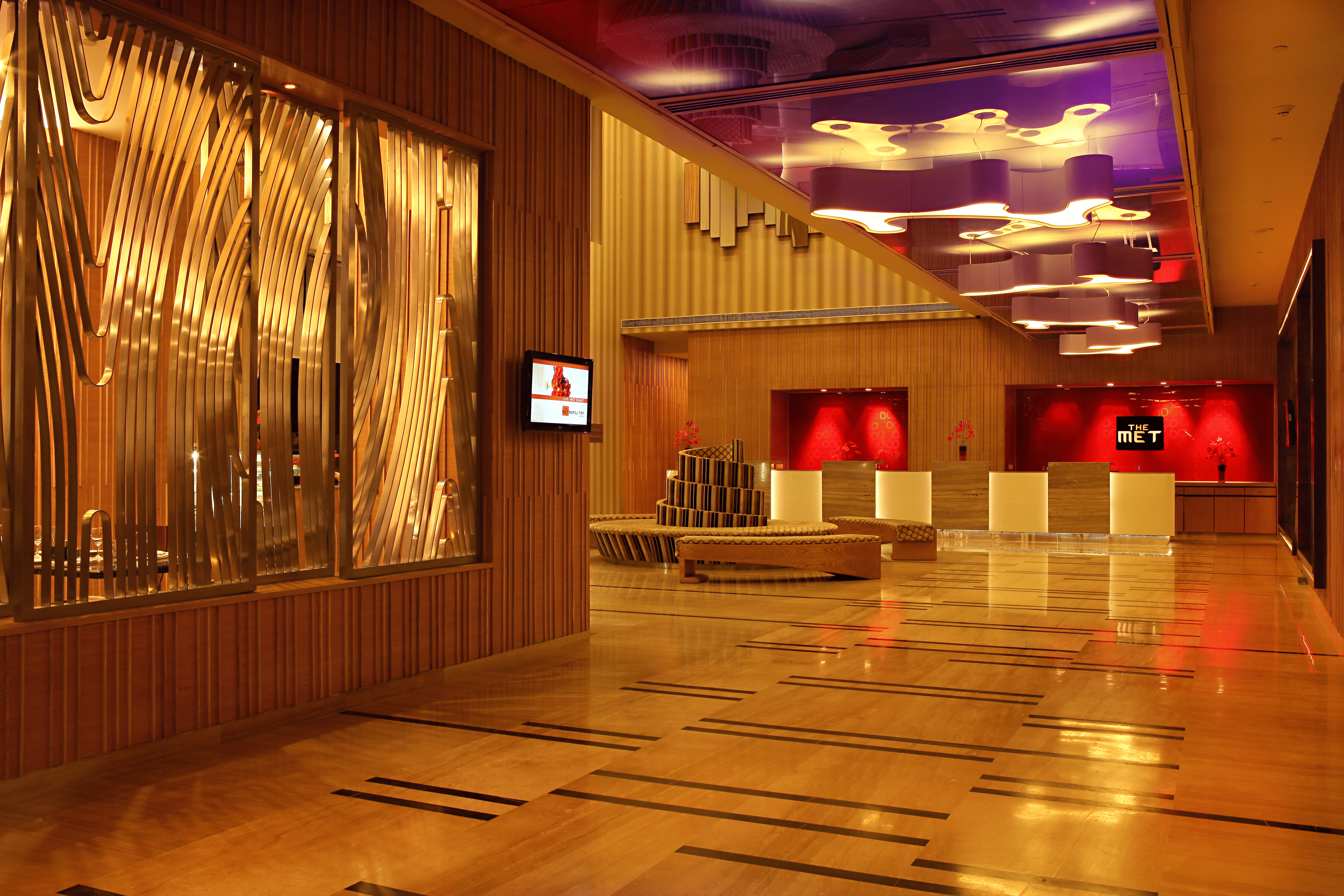 The lobby at THE MET, the reception desk lit against its red panel