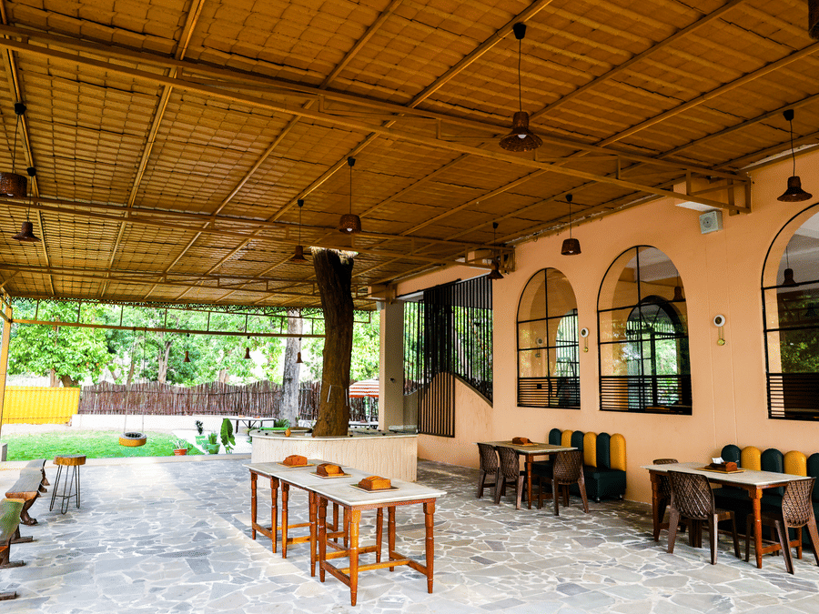 Outdoor seating under the pergola at Signum Resort, Bandhavgarh