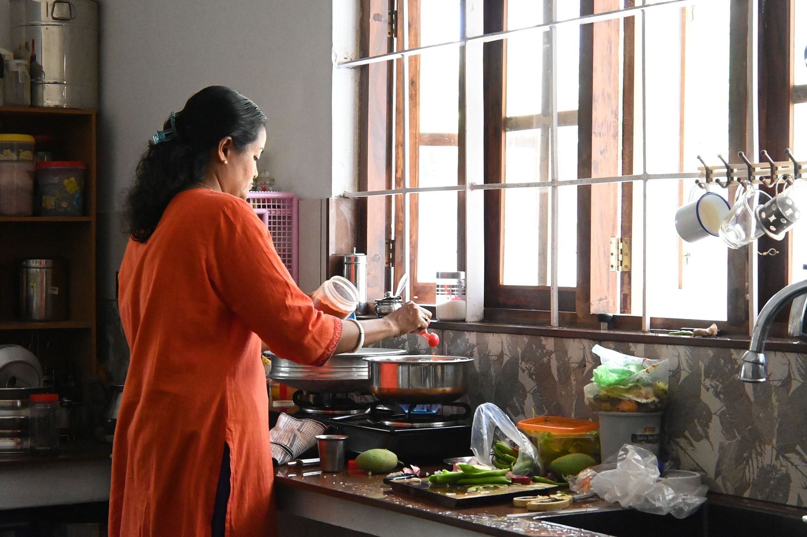 A women cooking in the kitchen at Ananda Holiday Home, Wayanad