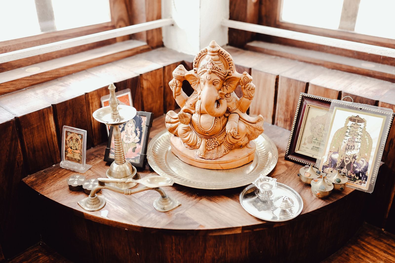 Image of an idol of lord Ganesha surrounded my multiple pictures of Hindu Gods at  Ananda Holiday Home, Wayanad