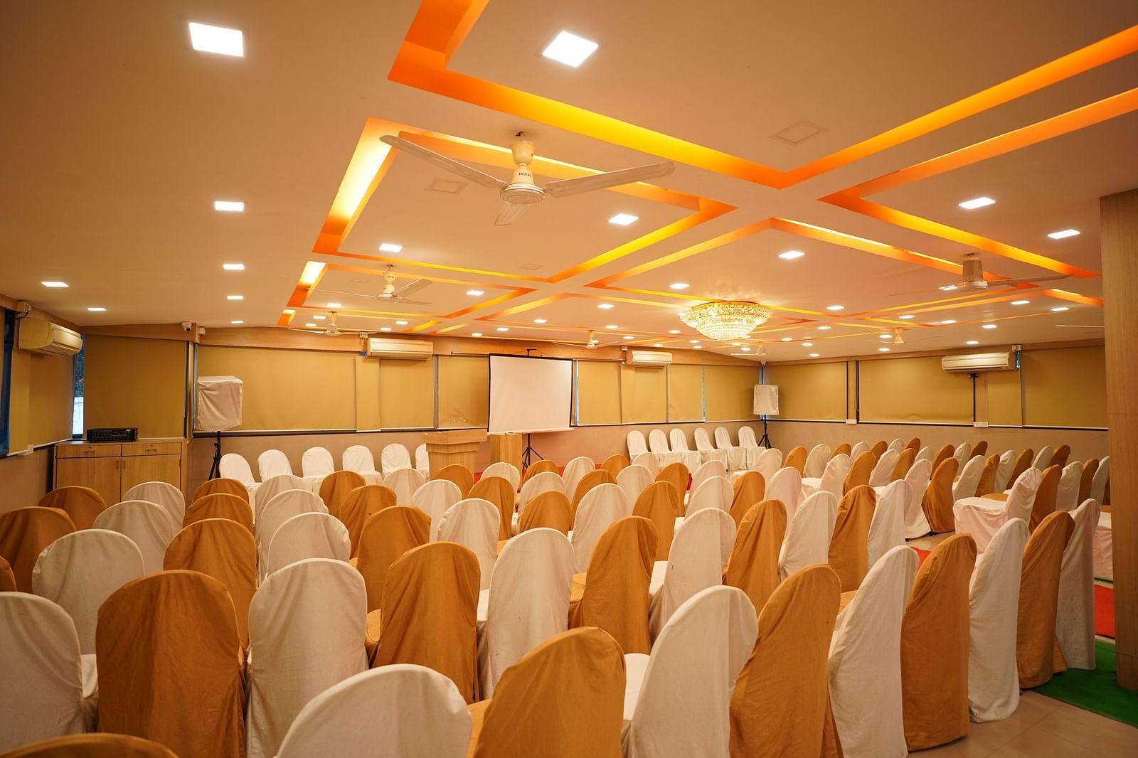 an image of a event hall with designed ceiling illuminating orange lights at  City Centre Residency, Bangalore