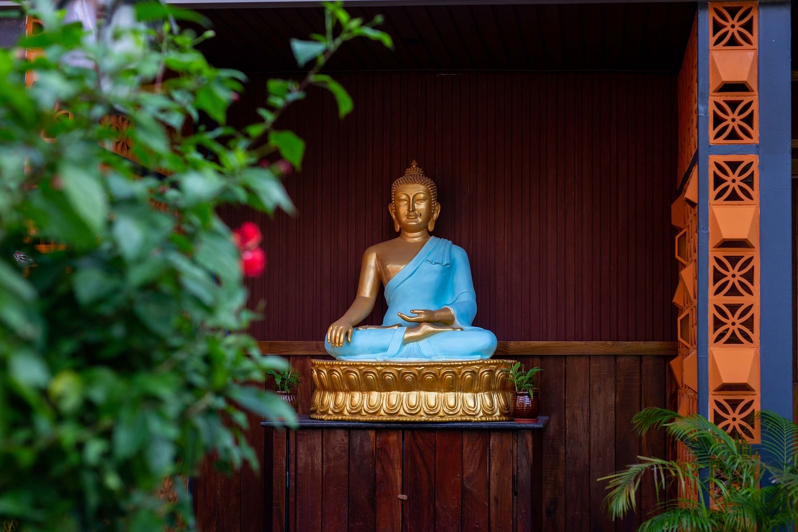 A peaceful image of a Buddha statue in a calm, natural setting. The statue is surrounded by greenery, creating a serene and meditative atmosphere - Coral Reef Resort & Spa, Havelock