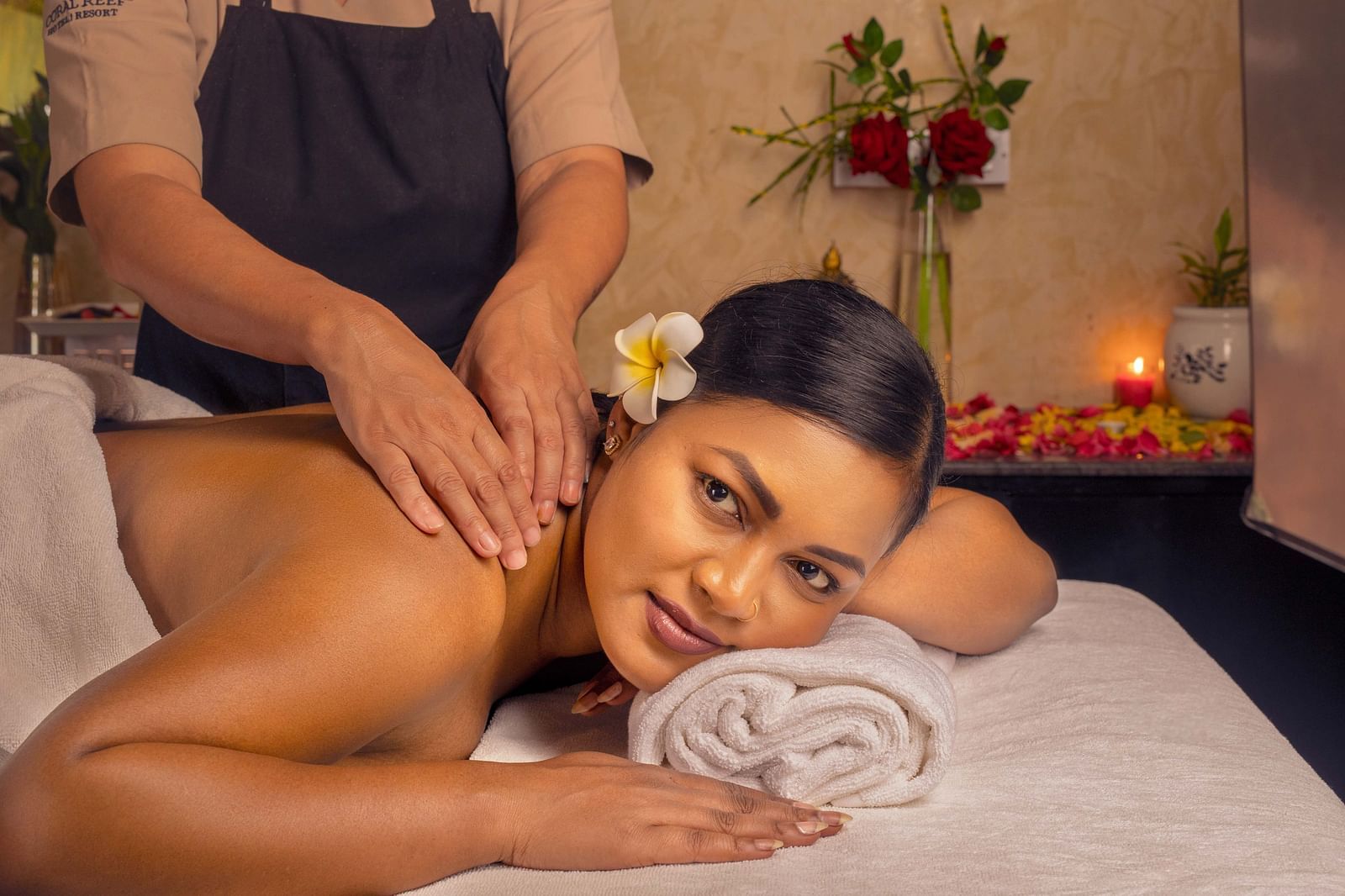 A close-up of a woman enjoying a relaxing massage in a peaceful spa setting. The warm lighting and delicate flowers around her enhance the calming atmosphere - Coral Reef Resort & Spa, Havelock
