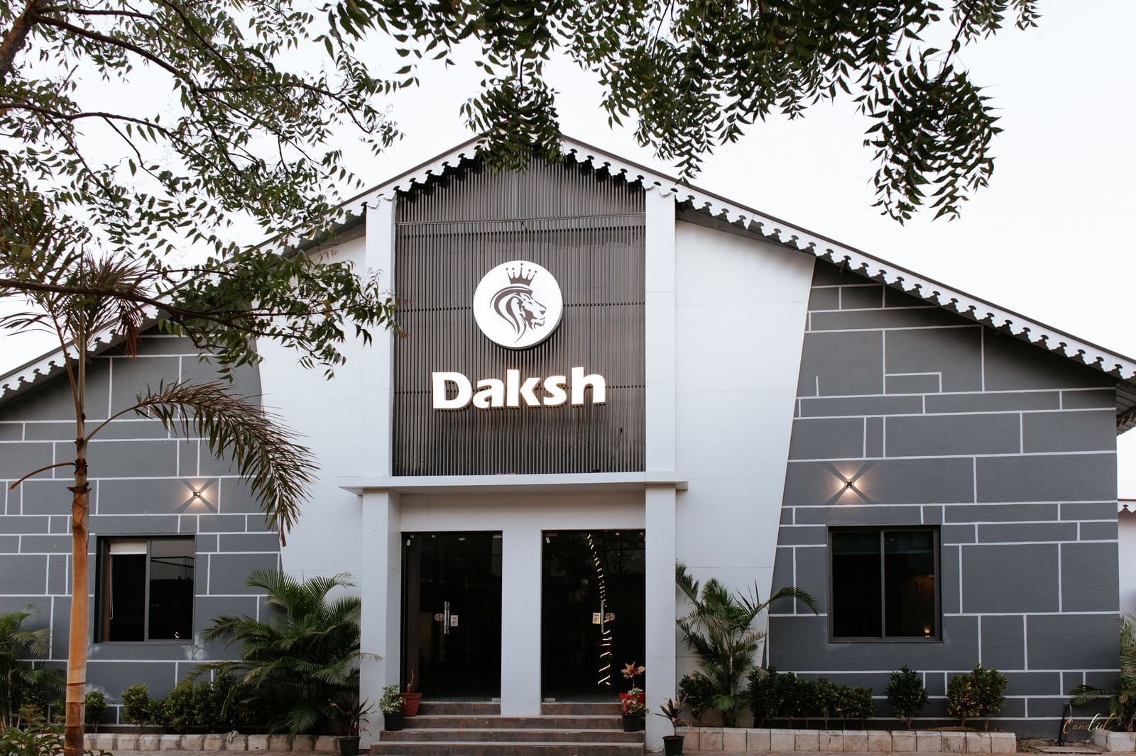 Shot of the facade of Daksh Eden Greenz in Sasan Gir with trees in the front.